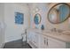 Bright bathroom with double vanity, white cabinets, large mirrors and stylish blue accents at 227 S Harbor Dr, Holmes Beach, FL 34217