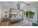 Serene main bedroom boasts a four-poster bed, vaulted ceiling, and a private balcony at 227 S Harbor Dr, Holmes Beach, FL 34217