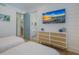 White bedroom with view to bath, coastal decor, two twin beds and mounted television at 227 S Harbor Dr, Holmes Beach, FL 34217