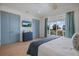 Bright bedroom features wood floors, blue accents, balcony with palm tree views and TV at 227 S Harbor Dr, Holmes Beach, FL 34217