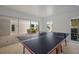 Inside game room area with ping pong table and sliding glass doors out to patio with dining set at 227 S Harbor Dr, Holmes Beach, FL 34217