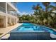 An eye-level view showcasing a bright blue pool and hot tub with palm trees and the home's exterior in the background at 227 S Harbor Dr, Holmes Beach, FL 34217