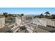 White Adirondack chairs on the rooftop deck offer scenic views of the neighborhood and the ocean at 227 S Harbor Dr, Holmes Beach, FL 34217