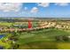 Aerial view of a beautiful home on a golf course with lush greenery and a serene lake in the community at 234 Padova Way, North Venice, FL 34275