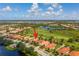 Aerial view showcases a golf course community with picturesque landscaping, scenic water views and beautiful homes at 234 Padova Way, North Venice, FL 34275