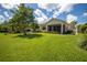The backyard features a grassy area with some plants and a screened-in porch at 234 Padova Way, North Venice, FL 34275