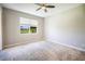 This bedroom has a neutral color, a ceiling fan, and a window with a view of the outdoors at 234 Padova Way, North Venice, FL 34275