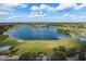Aerial view captures the picturesque golf course by the lake, with golf carts and blue skies at 234 Padova Way, North Venice, FL 34275