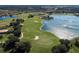Aerial view showcases a lush golf course with a scenic lake, manicured greens, and surrounding trees at 234 Padova Way, North Venice, FL 34275