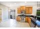 Well-lit kitchen features stainless steel appliances, granite countertops, ample cabinet space, and tile flooring at 234 Padova Way, North Venice, FL 34275