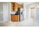 Kitchen area featuring stainless steel refrigerator, granite countertops, natural wood cabinets, and tile floors at 234 Padova Way, North Venice, FL 34275