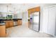 Spacious kitchen featuring stainless steel appliances, wood cabinetry, granite counters, and ceramic tile floors at 234 Padova Way, North Venice, FL 34275