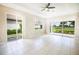 Bright living area with tile flooring, tray ceiling with fan, and sliding glass doors showcasing a golf course view at 234 Padova Way, North Venice, FL 34275