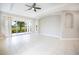 Open living space with tile flooring, tray ceilings, fan, and sliding glass doors with stunning golf course view at 234 Padova Way, North Venice, FL 34275