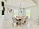 Bright dining room with a modern light fixture, and three large windows at 2425 Maclachlan St, Port Charlotte, FL 33953