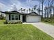 Charming single-Gathering home with a two-car garage and a well-maintained lawn and paved driveway at 2425 Maclachlan St, Port Charlotte, FL 33953
