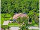 Beautifully landscaped home featuring a terracotta roof and lush, mature trees at 336 165Th Ne Ct, Bradenton, FL 34212