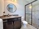Cozy bathroom features a vanity with granite countertop, round mirror, and shower with modern glass enclosure at 336 165Th Ne Ct, Bradenton, FL 34212