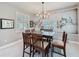 Well-lit dining room featuring a modern chandelier, stylish wall art, and large windows with plantation shutters at 336 165Th Ne Ct, Bradenton, FL 34212