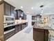Modern kitchen with dark cabinetry, granite countertops, and stainless steel appliances at 336 165Th Ne Ct, Bradenton, FL 34212