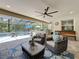Relaxing screened-in patio with ceiling fans, comfortable seating, and an outdoor kitchen overlooking the pool at 336 165Th Ne Ct, Bradenton, FL 34212