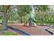 Community playground featuring slides, swings, and climbing structures nestled amongst mature trees and greenery at 336 165Th Ne Ct, Bradenton, FL 34212