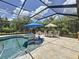 Sparkling pool and spa with sun loungers inside a screened-in enclosure at 336 165Th Ne Ct, Bradenton, FL 34212