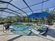 Stunning pool featuring in-pool loungers and a spillover spa inside a screened-in lanai, ideal for relaxation at 336 165Th Ne Ct, Bradenton, FL 34212