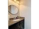 Elegant powder room featuring a granite countertop, oval mirror, and sleek fixtures, adding a touch of luxury at 336 165Th Ne Ct, Bradenton, FL 34212