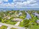 Waterfront home featuring lush landscaping, boat dock, large grassy yard and swimming pool under bright blue skies with fluffy white clouds at 336 Highland Shores Dr, Ellenton, FL 34222