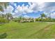 Sprawling front lawn with lush green grass and palm trees, offering a picturesque view of the home's exterior at 336 Highland Shores Dr, Ellenton, FL 34222