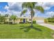 Charming home with a manicured front yard, featuring a bright blue door, a two-car garage, and mature landscaping at 336 Highland Shores Dr, Ellenton, FL 34222