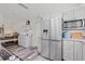 Bright kitchen with gray cabinets, stainless steel refrigerator, breakfast bar, and wood-look flooring at 336 Highland Shores Dr, Ellenton, FL 34222