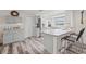 Bright kitchen with gray cabinets, stainless steel refrigerator, breakfast bar, and wood-look flooring at 336 Highland Shores Dr, Ellenton, FL 34222