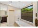 Bright bathroom with a soaking tub and view of tropical foliage at 3658 Torrey Pines Way, Sarasota, FL 34238