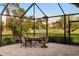 An outdoor patio with table, seating and gorgeous views of the lawn and trees at 3658 Torrey Pines Way, Sarasota, FL 34238