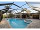 A beautiful enclosed pool with spa, outdoor living space and view of the main house at 3658 Torrey Pines Way, Sarasota, FL 34238