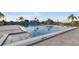 A beautiful outdoor pool, perfect for swimming laps with mature trees and blue skies at 3658 Torrey Pines Way, Sarasota, FL 34238