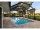 A screened in pool offering scenic outdoor views of the lawn and foliage at 3658 Torrey Pines Way, Sarasota, FL 34238