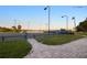 View of tennis courts at Sarasota Sports Club, showing well-kept grounds and lighting at 3658 Torrey Pines Way, Sarasota, FL 34238
