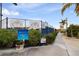 View of tennis court entrance surrounded by lush landscaping and signage at the Sarasota Sports Club at 3658 Torrey Pines Way, Sarasota, FL 34238