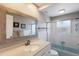 Bathroom features white cabinets, a framed mirror, and a shower with glass doors and a blue tiled bathtub at 3715 Bamboo Ter, Bradenton, FL 34210