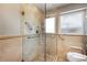 Tiled shower with glass door and grab bars, next to toilet with safety bars and window at 3715 Bamboo Ter, Bradenton, FL 34210