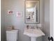 Small bathroom features a pedestal sink, toilet, framed art prints on the wall, and black hardware at 3715 Bamboo Ter, Bradenton, FL 34210