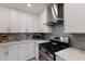 Close up of renovated kitchen area, with white cabinets, stainless appliances, and gray backsplash at 3715 Bamboo Ter, Bradenton, FL 34210