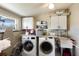 Clean laundry room with modern washer and dryer, folding counter, sink, and ample storage space at 3715 Bamboo Ter, Bradenton, FL 34210