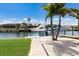 Waterfront view of private dock with boats, palm trees, and brick paver walkway at 3715 Bamboo Ter, Bradenton, FL 34210