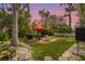 Lush backyard featuring a patio with dining set, lounge chair, grill, and ample green space at 403 29Th Nw St, Bradenton, FL 34205
