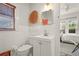 Bathroom features a white sink, cabinet, toilet and basket wall decor at 403 29Th Nw St, Bradenton, FL 34205