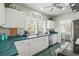 Well-lit kitchen featuring modern appliances, white cabinetry, and a view of the outdoors at 403 29Th Nw St, Bradenton, FL 34205